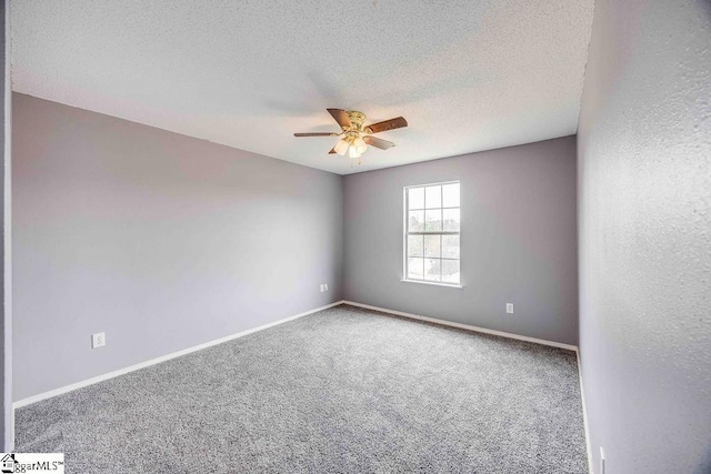 carpeted spare room featuring ceiling fan and a textured ceiling