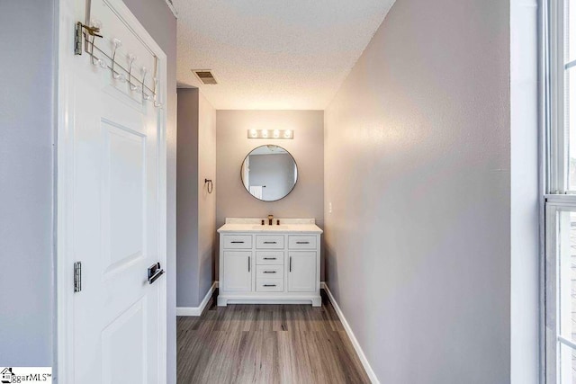 bathroom featuring vanity, hardwood / wood-style floors, and a textured ceiling