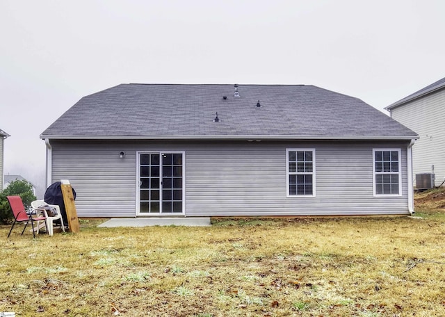 back of house featuring a yard and central AC