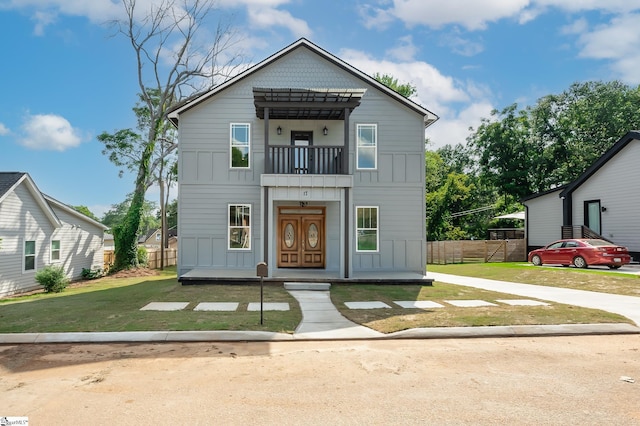 view of front of property with a front yard and a balcony