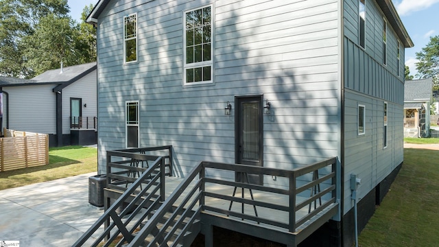 rear view of house with a lawn and a deck