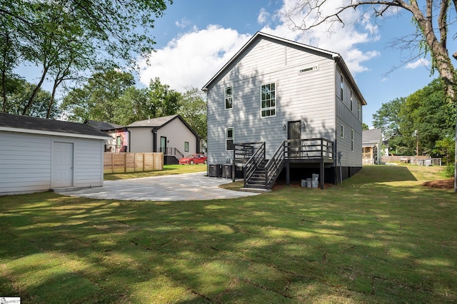 rear view of property featuring a patio area, a yard, and a wooden deck