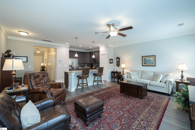 living room with ceiling fan, dark hardwood / wood-style flooring, and crown molding