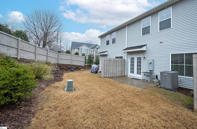 back of house featuring central air condition unit, a yard, and a patio