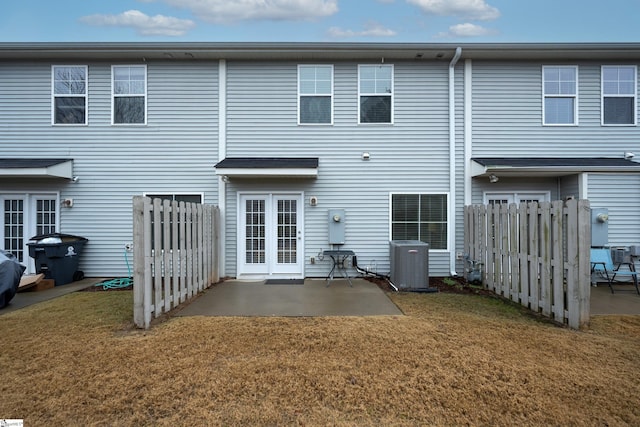 back of property with a yard, cooling unit, and a patio