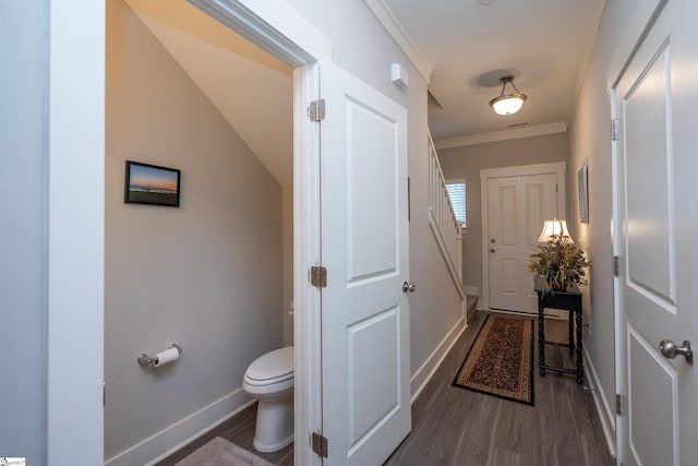 bathroom featuring wood-type flooring, toilet, and crown molding