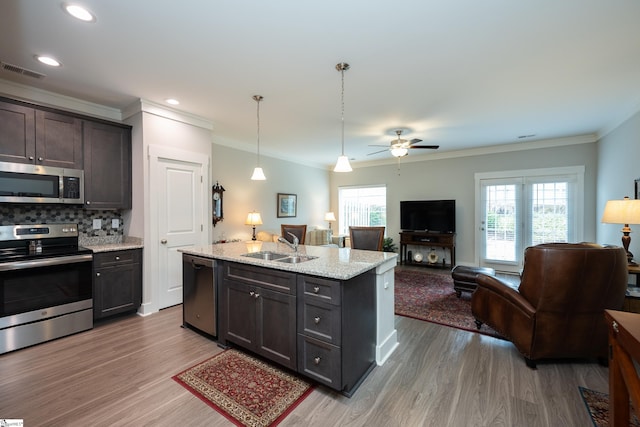 kitchen featuring light stone countertops, sink, stainless steel appliances, and wood-type flooring