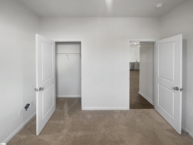 unfurnished bedroom with dark carpet and a closet