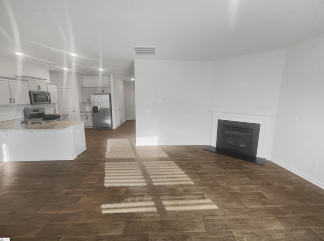 unfurnished living room with dark wood-type flooring