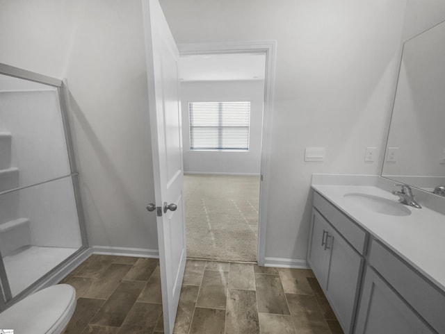 bathroom with wood-type flooring, vanity, toilet, and an enclosed shower