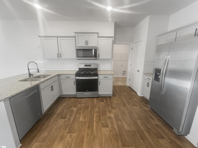 kitchen featuring white cabinetry, sink, stainless steel appliances, dark hardwood / wood-style floors, and decorative backsplash