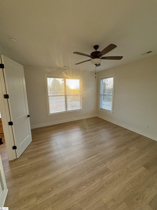 empty room with ceiling fan and light wood-type flooring