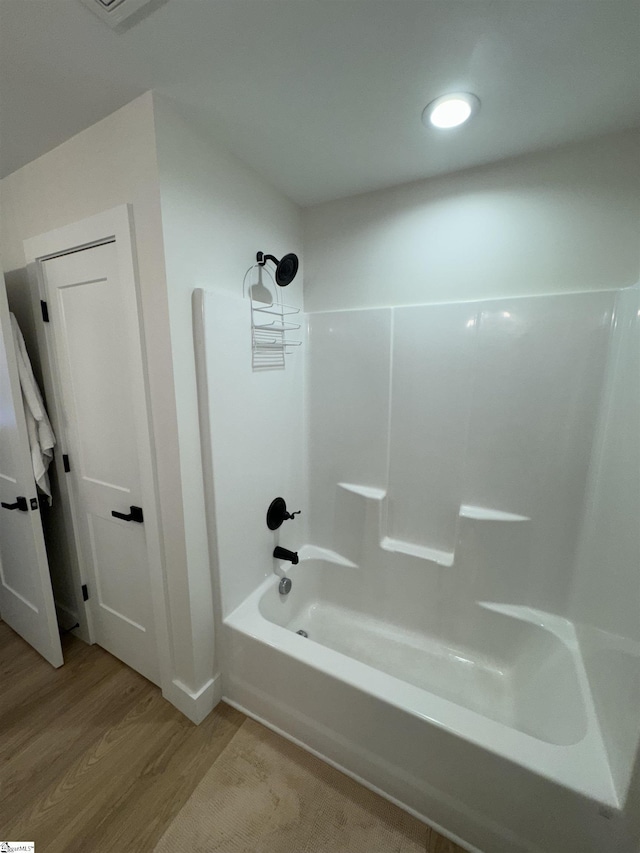 bathroom with shower / bathing tub combination and hardwood / wood-style flooring