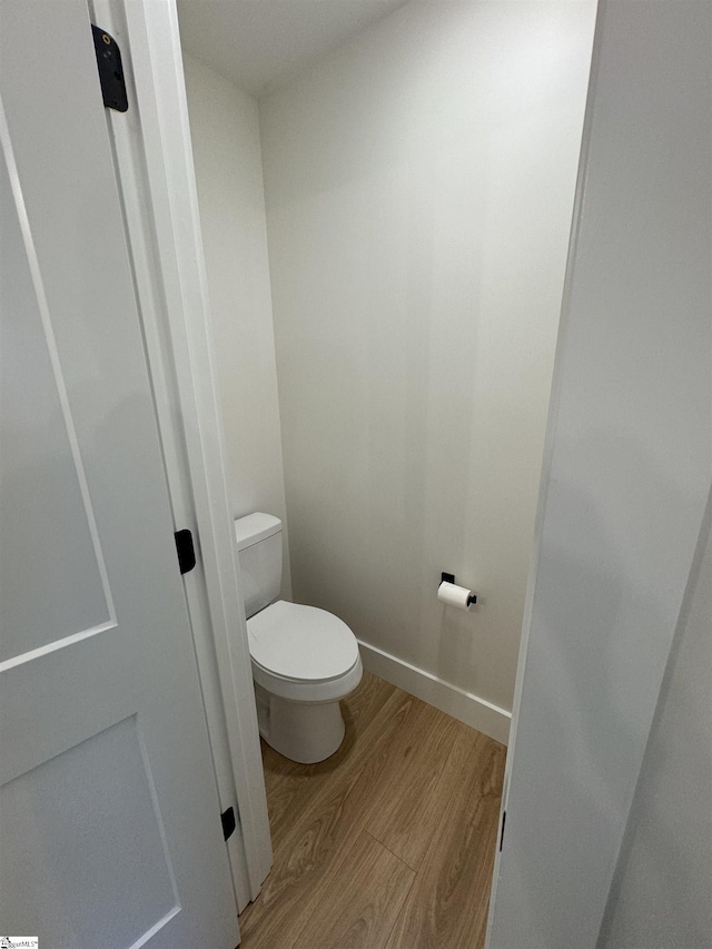 bathroom featuring wood-type flooring and toilet