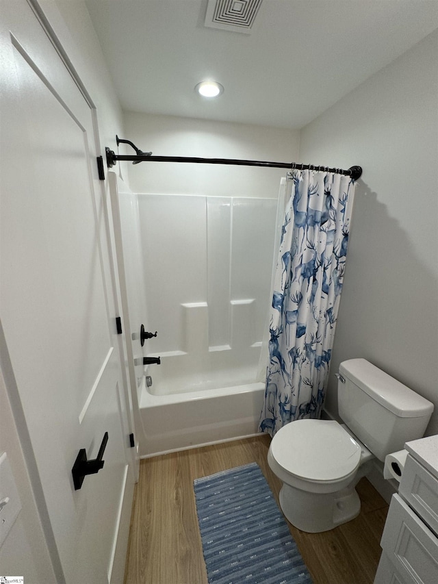 full bathroom featuring vanity, shower / tub combo, hardwood / wood-style flooring, and toilet