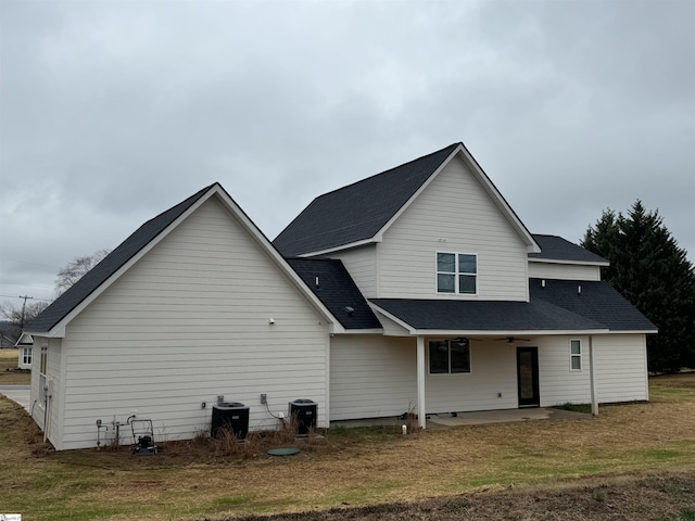 rear view of house with a patio, cooling unit, and a lawn