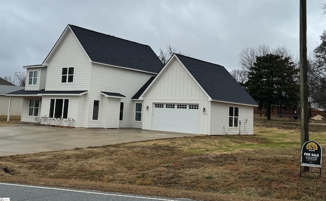 modern inspired farmhouse featuring a garage and a front lawn