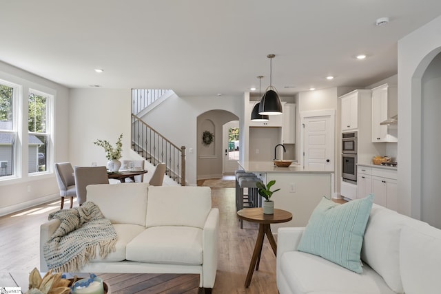 living room with light wood-type flooring and sink