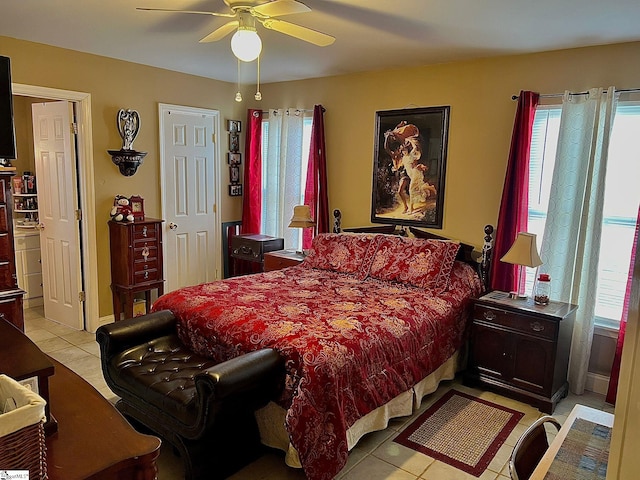 tiled bedroom featuring ceiling fan and multiple windows