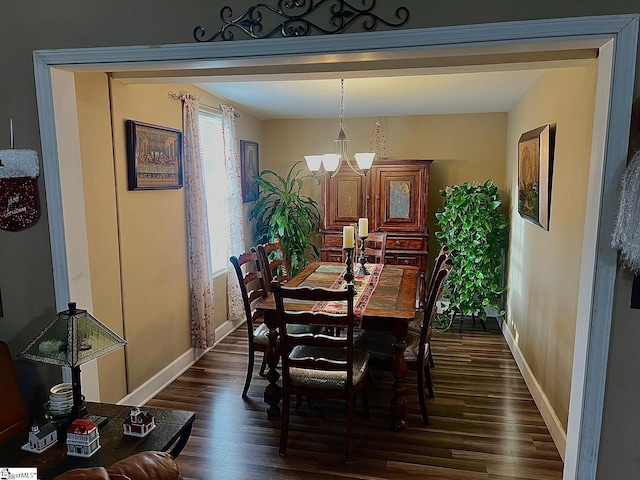 dining area featuring dark hardwood / wood-style flooring and an inviting chandelier