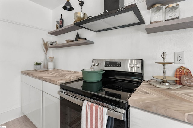 kitchen with white cabinets, light hardwood / wood-style floors, stainless steel range with electric cooktop, and range hood