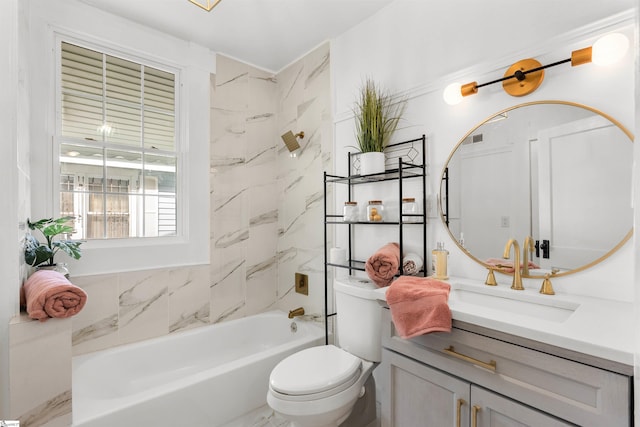 full bathroom featuring vanity, tiled shower / bath combo, and toilet