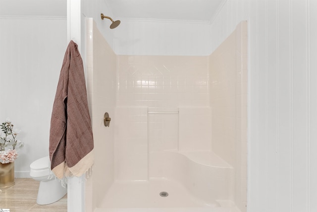 bathroom featuring toilet, walk in shower, and ornamental molding