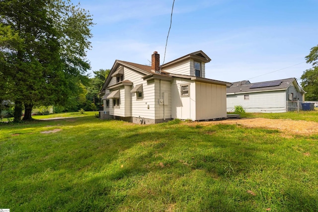 rear view of house with a yard and central AC unit