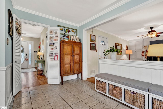 interior space with light wood-type flooring, ceiling fan, and crown molding