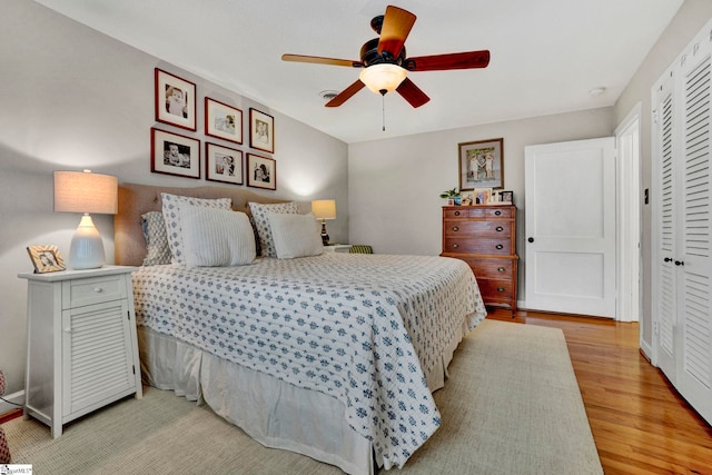 bedroom with light wood-type flooring, a closet, and ceiling fan