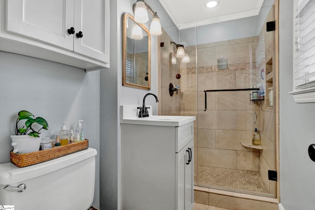 bathroom with vanity, toilet, a shower with shower door, and ornamental molding