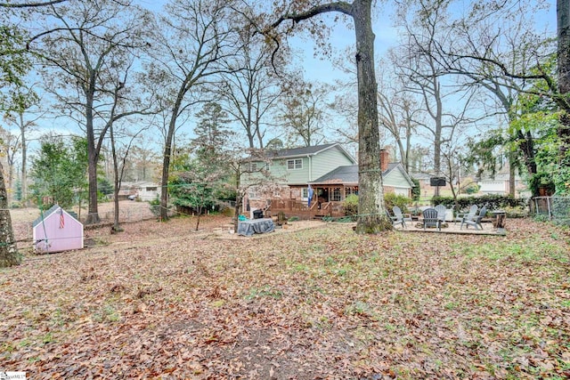 view of yard featuring a patio, a shed, and a deck