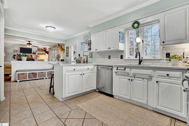 kitchen featuring dishwasher, white cabinets, decorative backsplash, light tile patterned floors, and kitchen peninsula