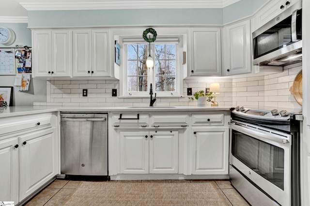 kitchen with sink, white cabinets, stainless steel appliances, and light tile patterned floors