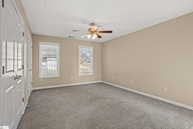 carpeted spare room featuring ceiling fan