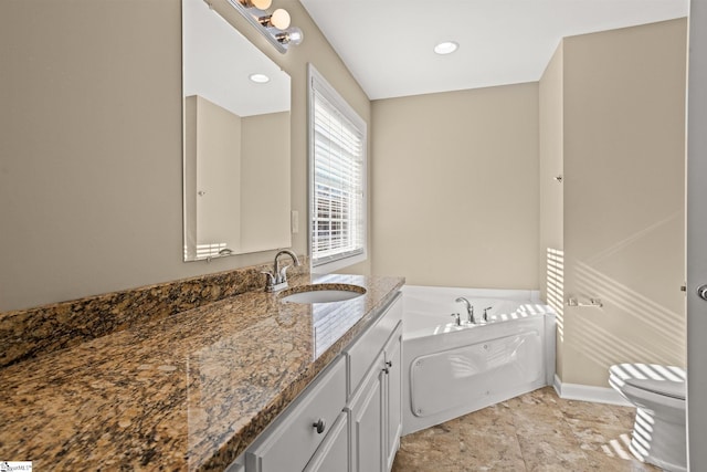 bathroom with vanity, toilet, and a tub