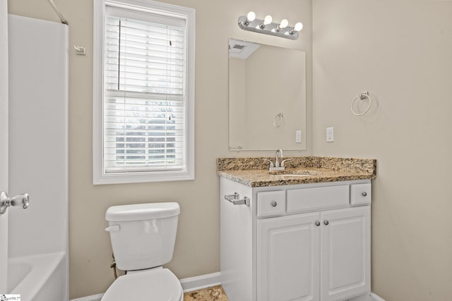 bathroom with vanity, toilet, and a healthy amount of sunlight