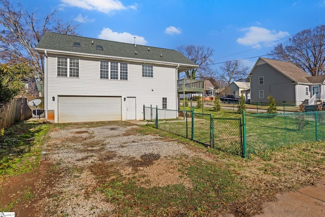 rear view of property with a garage and a lawn