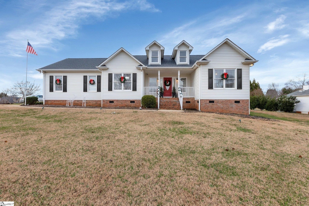 cape cod-style house with covered porch and a front yard