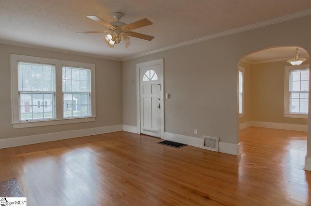 entrance foyer featuring a textured ceiling, light wood-type flooring, ceiling fan, and ornamental molding