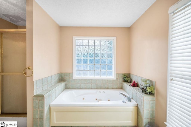 bathroom featuring separate shower and tub and a textured ceiling