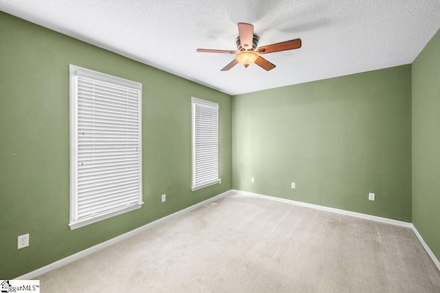 unfurnished room with carpet flooring, a textured ceiling, and ceiling fan