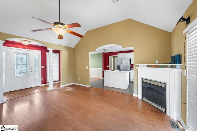 unfurnished living room with light hardwood / wood-style floors, ceiling fan, lofted ceiling, and decorative columns