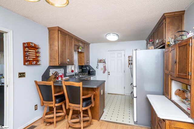 249 Monroe Bridge Rd, Honea Path, SC 29654 - kitchen with stainless steel fridge, sink, a textured ceiling, and light hardwood / wood-style flooring
