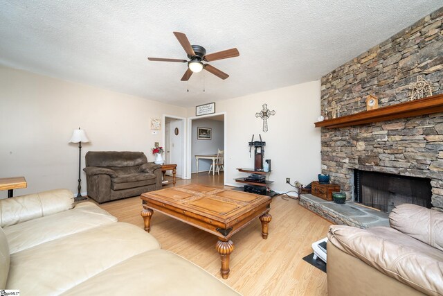 249 Monroe Bridge Rd, Honea Path, SC 29654 - living room with a stone fireplace, a textured ceiling, and light hardwood / wood-style flooring