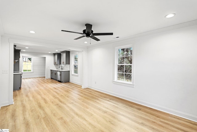 unfurnished living room with crown molding, sink, ceiling fan, and light hardwood / wood-style floors