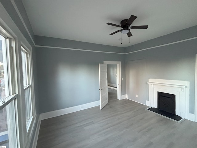 unfurnished living room featuring hardwood / wood-style flooring and ceiling fan