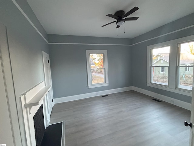 unfurnished living room featuring hardwood / wood-style flooring, ceiling fan, and a wealth of natural light