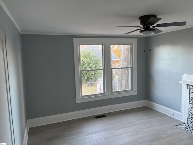 unfurnished room featuring ceiling fan, light hardwood / wood-style floors, and ornamental molding