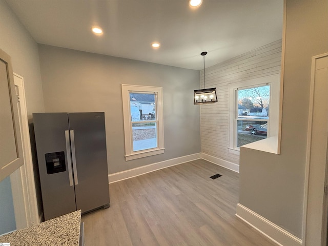 unfurnished dining area with hardwood / wood-style flooring and a chandelier